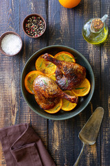Baked duck legs with oranges and rosemary. Rustic style.