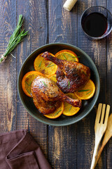 Baked duck legs with oranges and rosemary. Rustic style.
