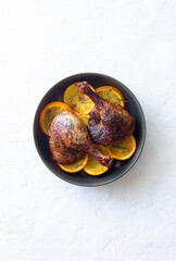 Baked duck legs with oranges and rosemary. Rustic style.