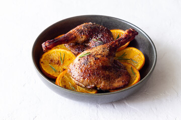 Baked duck legs with oranges and rosemary. Rustic style.