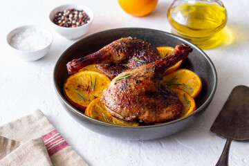 Baked duck legs with oranges and rosemary. Rustic style.