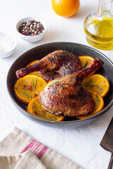 Baked duck legs with oranges and rosemary. Rustic style.