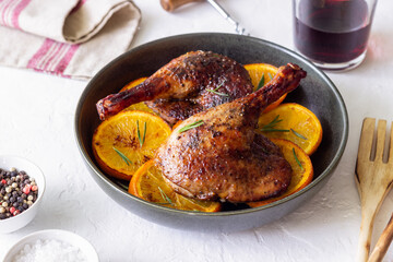 Baked duck legs with oranges and rosemary. Rustic style.
