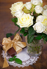 bouquet of blossoming roses in vase on a wooden background