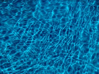 Beautiful refreshing blue swimming pool water background copy space