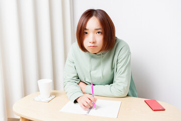 Naklejka premium リビングで勉強をしている若い女性