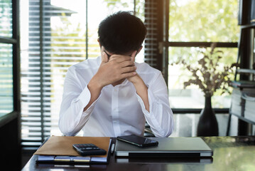 Young frustrated male working at office desk in front of laptop suffering from chronic daily headaches, treatment online, appointing to a medical consultation, electromagnetic radiation, sick pay