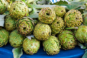 Obraz premium Fresh green artichokes on the farmers market stall