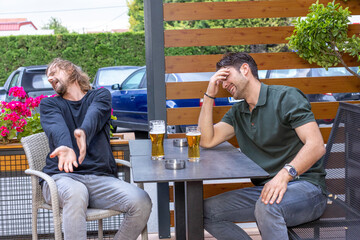Disappointed friends watching football game, upset about loss, drinking beer in the outdoor bar