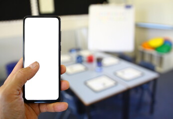 Teacher using smart device for banking or online shopping in the classroom. 