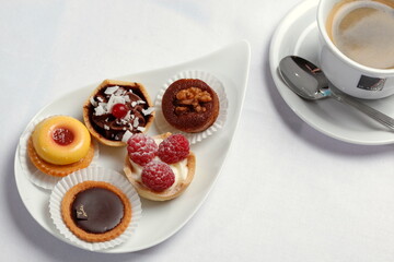 Petits Fours, kleine Kuchen auf Servierplatte, Tasse Kaffee