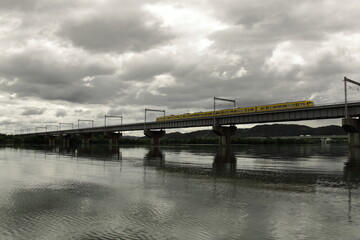 水面に映る鉄橋と雲り空