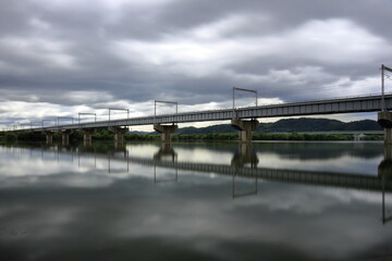 	水面に映る鉄橋と雲り空