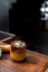 Ice coffee on a table with cream being poured into it showing the texture and refreshing look of the drink