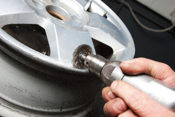Obraz premium Mechanic changing car wheel in auto repair shop