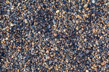 Crushed stone on the seashore. Selective focus on object. The stones were laid on the ground in the garden as a background. Background blur. Pebble stones background.