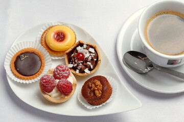 Petits Fours, kleine Kuchen auf Servierplatte, Tasse Kaffee