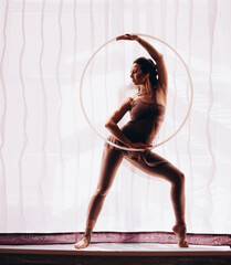 Silhouette of Beauty woman dancing with hula hoops. Hula-hoop