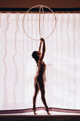 Silhouette of Beauty woman dancing with hula hoops. Hula-hoop