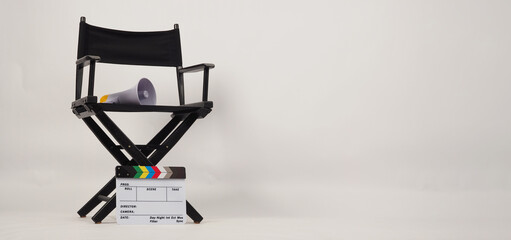 Black director chair and white clapper board with yellow megaphone on white background