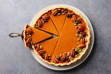 Pumpkin pie on a plate. Grey background. Close up. Top view.