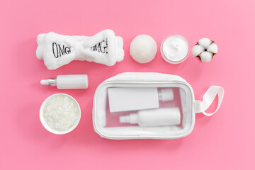 Set of cosmetic bag with white makeup bottles and tubes, top view