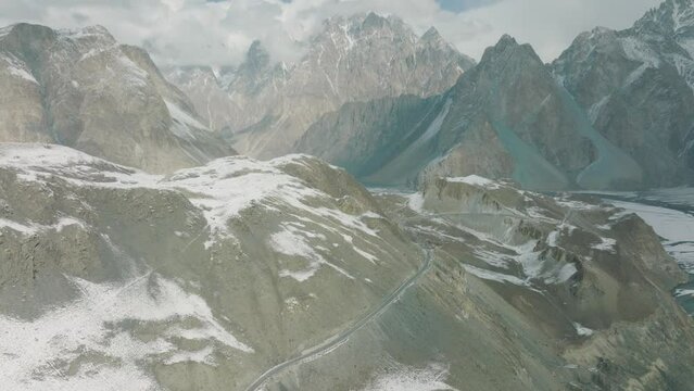 Aerial View Of Winter Empty Road In Passu With Tilt Up View Of Passu Mountain Peak Landscape. Dolly Forward