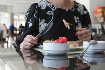 Young woman having breakfast in restaurant	