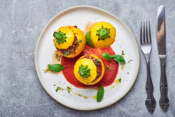 Stuffed zucchini. Round yellow zucchini stuffed with meat and vegetables served on plate.