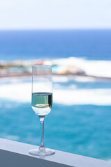 Champagne glass on balcony with spectacular sea view in luxury hotel. Tropical vacation and summer time concept