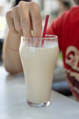 Man soaking a pastry in a glass of frozen vegetal drink (horchata)