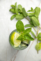 non-alcoholic cocktail, lemonade. With mint, ice, lime on a gray table