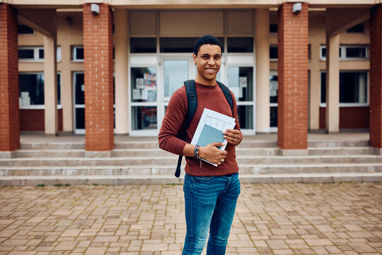 Happy Black Student In Front Of College Building Looking At Camera.