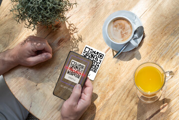 A customer scanning a qr code with his cell phone in a bar or restaurant to read the menu. The hospitality industry and new technologies