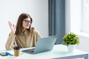 Young business woman having video call via laptop in the office