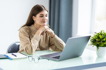 Experienced businesswoman reading publication via laptop making research for planning startup at desktop