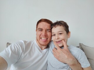 Fototapeta premium selfie son and dad, the concept of family values and selfie photo. Little boy with his dad taking selfie at home. Father and son spending time together