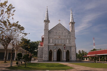Fototapeta na wymiar Gray color church and blue sky, Nativity of Our Lady Catherdral at Samutsongkram province,Thailand.