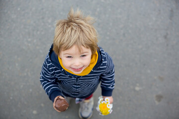 Cute blond child, boy, eating ice cream in the park