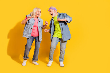 Photo of sweet funny girlfriend boyfriend dressed denim outfit dancing empty space isolated yellow...