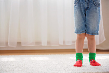 Child feet with different socks standing in rows, kids wearing different socks