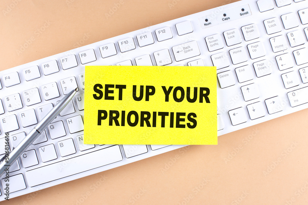 Poster text set up your priorities text on a sticky on keyboard, business concept
