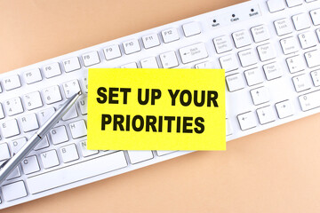 Text SET UP YOUR PRIORITIES text on a sticky on keyboard, business concept