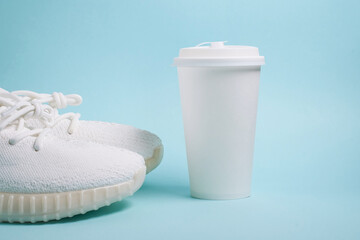 Mock up. White sneakers and a white paper cup with coffee