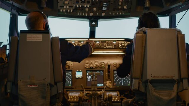 Plane captain and woman copilot fixing altitude on dashboard, using cockpit command with control panel to fly airplane. Aerial navigation to takeoff and use power engine, airline service.