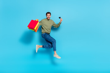 Fototapeta na wymiar Full body portrait of handsome excited guy show debit plastic card isolated on blue color background