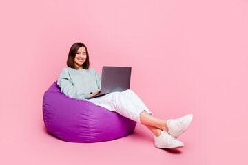 Full size profile side photo of youth woman sit chair manager use laptop typing isolated over pink...