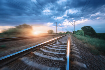 Fototapeta na wymiar Railroad and cloudy blue sky at sunset with motion blur effect