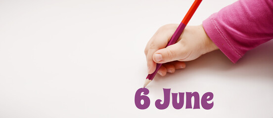 A child's hand writes 6 june in a lilac pencil. Banner with copy space