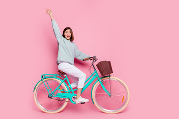 Full body profile side photo of young pretty woman good mood riding bicycle free-time isolated over...
